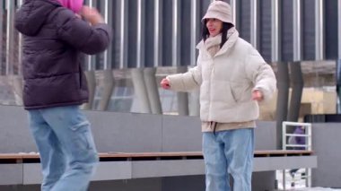 Kentsel bir yüzeyde bireysel bir paten kayıyor ve arka planda modern binalarla ilgili yetenekler sergiliyor.