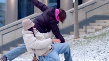 Kaygan buzlu merdivenlerde kayan bir insan, tuhaf bir şekilde karlı bir arka plan manzarasının ortasına düşüyor.