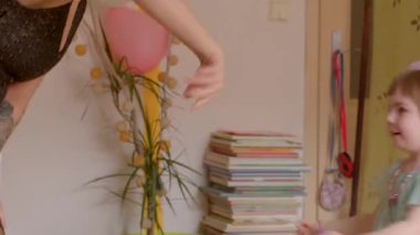 Neşeli ve neşeli bir ortamda, bir çocuk mutlu bir şekilde bir yetişkinle etkileşime girer ve onunla oynar, neşe ve eğlence yaratır.