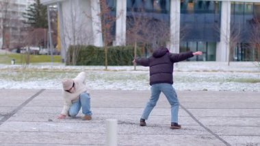 İki neşeli çocuk, kış mucizeleriyle dolu karlı bir ortamda neşeyle oynuyorlar.