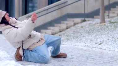 Birisi kaygan kar üzerinde kayıyor ve başka biri geçiyor, komik olaydan habersiz.