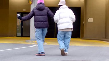 Canlı bir şehirde, iki insan şık kışlık ceketler ve takkelerle birlikte dans eder, ruhlarını gösterirler.