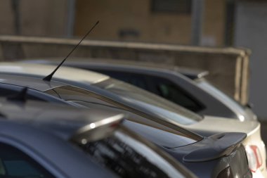 Geniş bir otoparkta, düzgün bir şekilde yan yana park edilmiş bir sürü araba değerli park yerlerini kaplıyor.