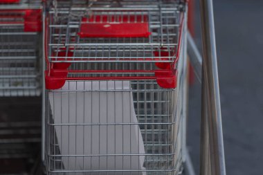 Bir rulo tuvalet kağıdı içeren bir alışveriş arabası, perakende alışveriş gezilerinde ev ihtiyaçlarını ve kolaylıkları vurguluyor.