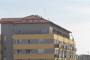 Parlak kırmızı bir çatısı olan büyük ve etkileyici bir bina ve yeterli ışığın içeri girmesine olanak sağlayan bolca pencere var.