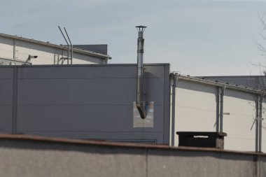 Kenarlarından birinde belirgin bir baca bulunan bir bina var, genel dizaynına ve görünümüne karakter katıyor.