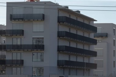 Dış kısımları boyunca sayısız pencere ve birden fazla balkona sahip bir mimari yapı veya bina, bir görünüm sunuyor