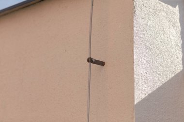 Dış duvarın kenarına yerleştirilmiş metal bir vidanın detaylı yakın plan görüntüsü yapısal önemini gözler önüne seriyor.