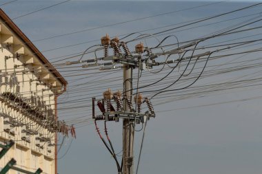Elektrik dağıtımı ve genel olarak elektrik şebekesini desteklemek için üzerinde sayısız kablo bulunan uzun bir telefon direği.
