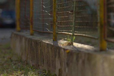 Bu, olay yerine ilginç bir odak noktası ekleyen kırık cam pencereli bir çitin yakın plan görüntüsü.