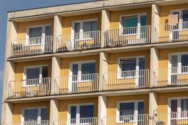 Çok sayıda balkon ve yapısında bolca pencere bulunan büyük ve etkileyici bir apartman.