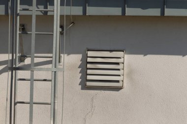 Sağlam bir merdiven yüksek bir binanın kenarına güvenli bir şekilde bağlanır, bakım ve onarım için farklı katlara erişimi sağlar.