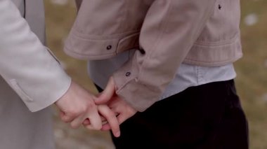 Büyüleyici bir video, romantik bir günde beyaz önlüklü bir çift ve pembe ceketli bir ortağın, hassas anların tadını çıkardığı bir çift gösteriyor.