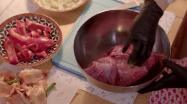 Bu video kaseye taze et koyup sebzelerle dolu bir tavaya ekleyerek bir et yemeği hazırlıyor.