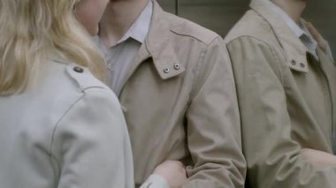 Bu romantik kısa filmde, bir erkek ve kadın asansörde güzel bir anı paylaşıyorlar, el ele tutuşuyorlar ve şık trençkotlarla sarılıyorlar, aşkı simgeliyorlar.