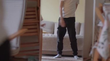 Genç bir kız pembe bir etekle neşeyle dans ediyor, parlak bir odada yansıyor.