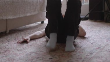 Bir birey, yumuşak bir halının üzerinde rahat bir şekilde dinlenir ve sıcak, rahat bir atmosfer yaratır.