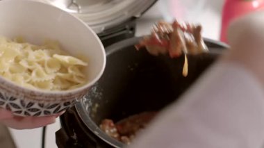 Bu video yemek pişirme sanatını gözler önüne seriyor, kaynayan bir çorbaya taze malzemeler ekleniyor ve yemek sevenler için mükemmel bir elektrikli düdüklü tencere kullanılıyor.