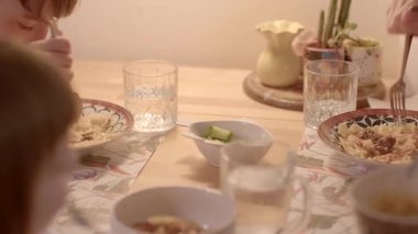 İki neşeli çocuk yemek masasında zevkli bir arka plan dekoruyla eğleniyor.