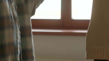 Pencere kenarında, bir erkek ve kadın samimi anlar paylaşır, el ele tutuşarak bağlarını gösterirler ve profesyonel bir tokalaşma güveni simgeler.