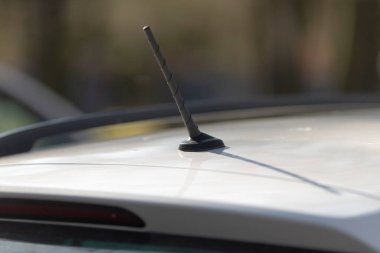 Bir aracın çatısına yerleştirilmiş bir antenin detaylı bir yakın çekim görüntüsü, otomotiv tasarımı özellikleri hakkında içgörü sağlıyor