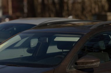 Belirlenmiş bir otoparkta, yan yana park edilmiş iki araba var, bitişik park yerlerini işgal ediyorlar.