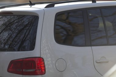 Kırmızı stop lambalı beyaz bir SUV şu anda yolun kenarına park edilmiş durumda. Bu da yoldan geçenlerin dikkatini çekiyor.