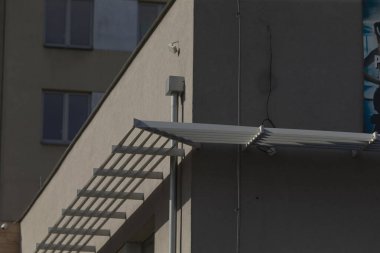 En tepesine kadar uzanan ve erişimi ve manzarayı yükselten bir dizi merdiveni olan bir bina.