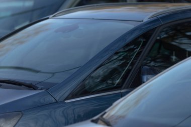 Belirlenmiş bir otoparkta, birden fazla araba düzgün bir şekilde yan yana dizilir, kullanılmayı bekleyen bir sıra park edilmiş araç oluşturulur.