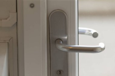 Bu, el değmemiş beyaz bir kapıya bağlanmış bir kapı kolunun yakın görüntüsü. Tasarımı ve detaylarını daha iyi bir takdir için açıkça gösteriyor.