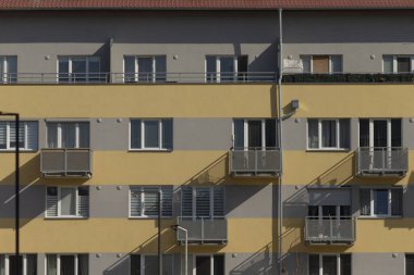 Çok sayıda pencere ve estetik cazibesini ve işlevselliğini arttıran birden fazla balkondan oluşan etkileyici bir bina tasarımı.