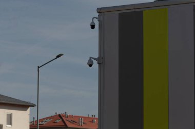 Yan tarafına kamera monte edilmiş bir bina var. Güvenlik gözetleme yeteneklerini arttırıyor.