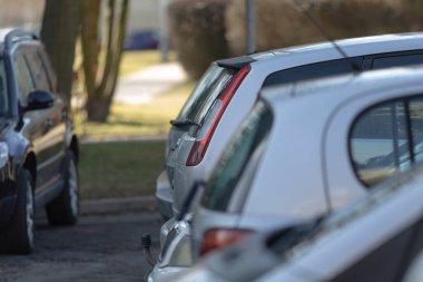 Bulanık bir arka plan ilginç bir atmosfer yaratırken, sayısız araba cadde boyunca park halinde.