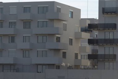 Çok sayıda penceresi ve çok sayıda balkonu olan büyük bir bina, şehir yaşamı için mükemmel, kapalı alanlarda bol miktarda doğal ışık sağlıyor.