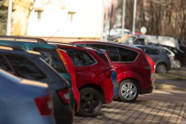 Park halindeki arabalar ve ağaçlarla dolu geniş bir park alanı.