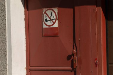 Kahverengi ahşap kapıda sigara içilmez işareti var. Girişte kesin kısıtlamalar var.