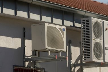 Bir binanın dış duvarına monte edilmiş iki havalandırma ünitesi vardır.