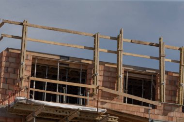 Sitede, yeni bir yapı oluşturma amaçlı bir inşaat projesi için iskeleler ve çerçeveler yer alıyor