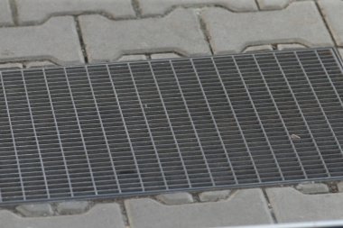 Kaldırım kenarındaki metal ızgara suyu boşaltmaya ve yürümek için istikrar sağlamaya yarar.