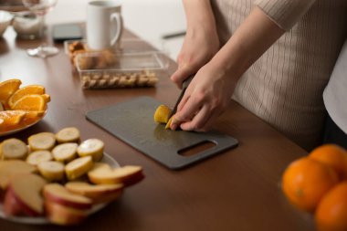 Süreç, mutfak ortamında çeşitli taze meyveleri dikkatlice hazırlayıp kesmeyi içeriyor.