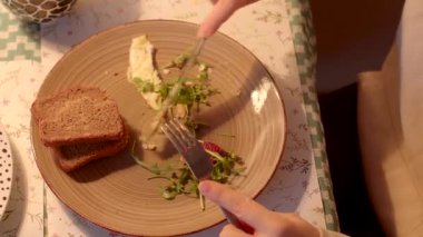 Taze ekmek, canlı yeşiller ve mükemmel pişirilmiş omlet ile güzel bir şekilde düzenlenmiş bir tabak.