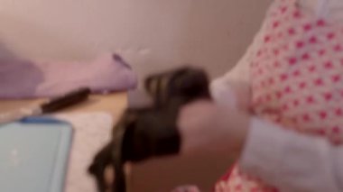 Siyah eldivenli bir figür esrarengiz bir nesne tutar, daha derin hikayeleri ima eder. Bir kadın avokadoyu kesip entrikayı normallikle harmanlarken, bir kişi yatakta oturup savunmasızlığı çağrıştırıyor.