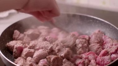 Bu video, pişirme sürecinin ve seslerin altını çizerek, bir insan olarak pişirilen eti kızartma tavasında ustalıkla hazırlıyor.