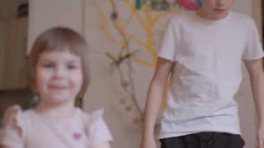 Rahat çoraplar giymiş neşeli bir çocuk evde oynayıp eğleniyor ve eğleniyor.