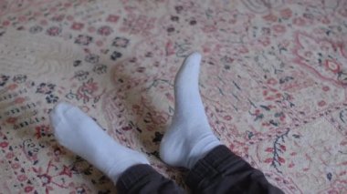 Bu video, rahat bir yerde dinlenen, yumuşak bir halı ve yatağa uzanan, sükunet ve rahatlığı somutlaştıran, rahat bir atmosfer sergiliyor.