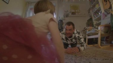 Bir çocuk ve bir yetişkin, mutlu bir şekilde yumuşak bir halıda amuda kalkarlar, neşeli bir bağ kurma aktivitesinin tadını çıkarırlar.