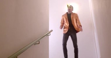 Kendine güvenen bir insan şık bir kıyafetle merdivenlerden aşağı iniyor, parlak bir geçmişi var ve olay yerine hayat katıyor.
