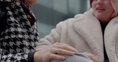 Kadınlar canlı bir şekilde şehir zeminine karşı sohbet ediyorlar, bağlantılarını ve etkileşimlerini gösteriyorlar.