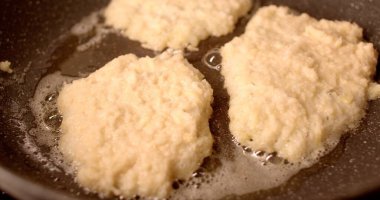 Köfteler ocakta kızgın yağda kızarıyor, çıtır çıtır dokularını açığa çıkarıyor ve onları lezzetli yapan karmaşık pişirme sürecini gözler önüne seriyor.