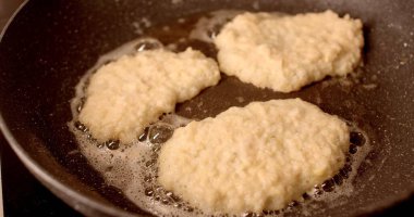 Bir tavada hamur parçalarını kızgın yağda kızartma işlemi, lezzetli kızarmış gıdaların eğlence ve tüketime hazırlanmasında kullanılan çeşitli aşamaları gözler önüne seriyor.